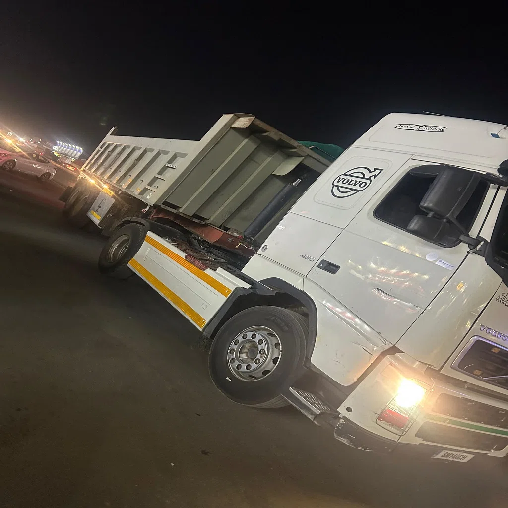 شاحنة فولفو نقل ثقيل بمقطورة قلاب متوقفة ليلًا على الطريق، تُستخدم في نقل المواد والحمولات الثقيلة